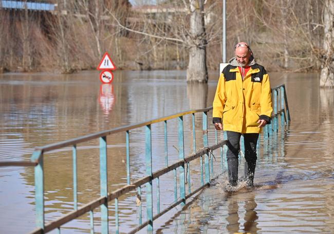 Un vecino camina sobre la zona inundada.