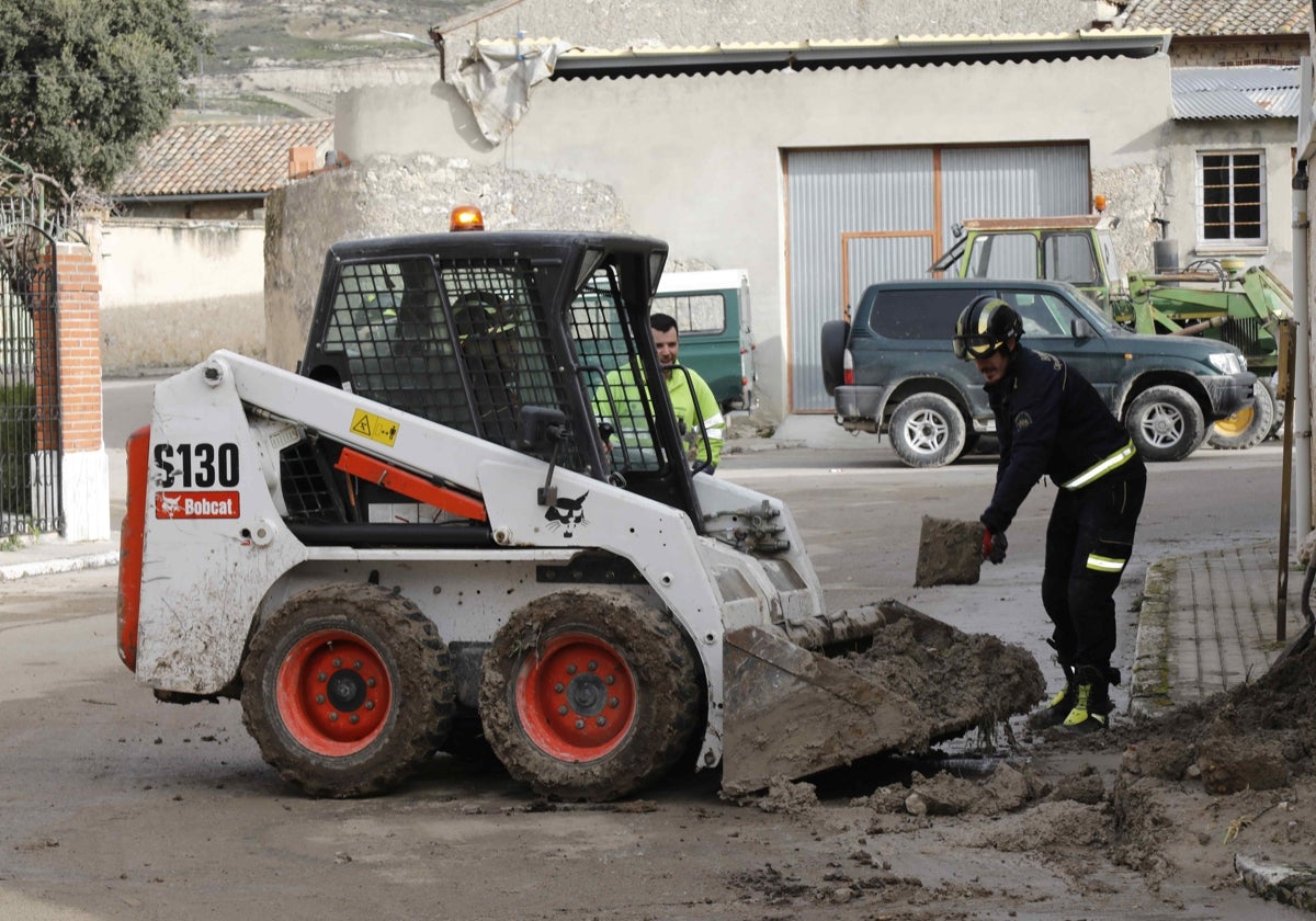 Bomberos de Peñafiel y persona del Ayuntamiento de Rábano retiran el barro de las calles.