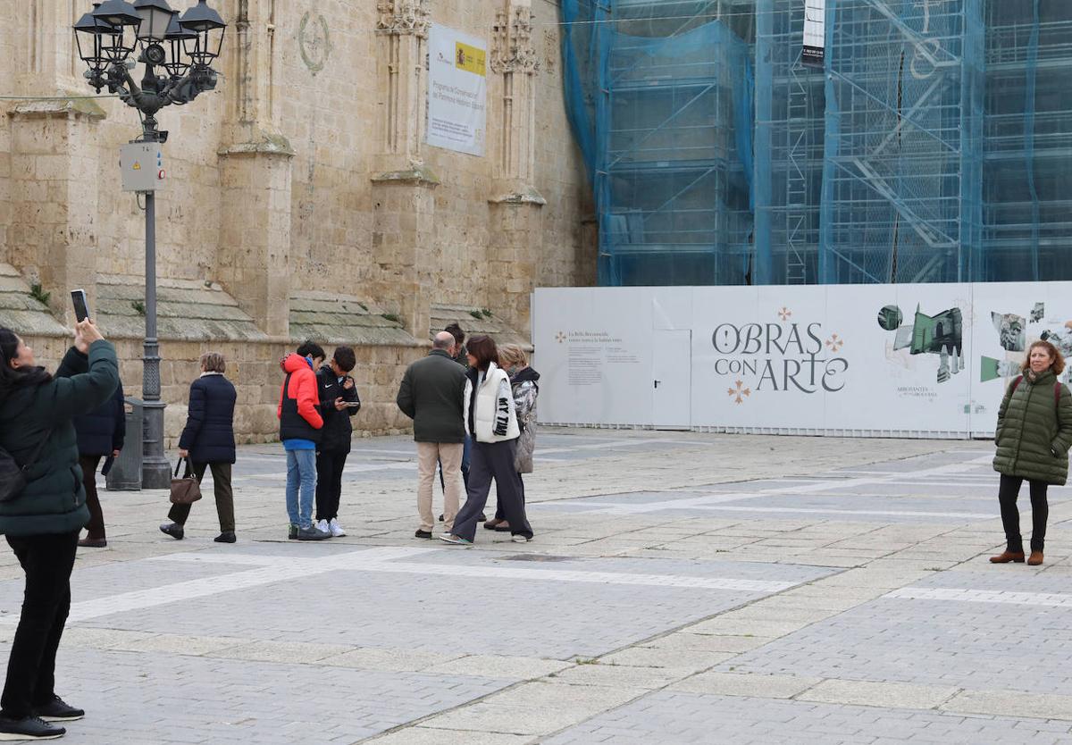 Una mujer fotografía a otra delante de la Catedral y junto a otro grupo de turistas.