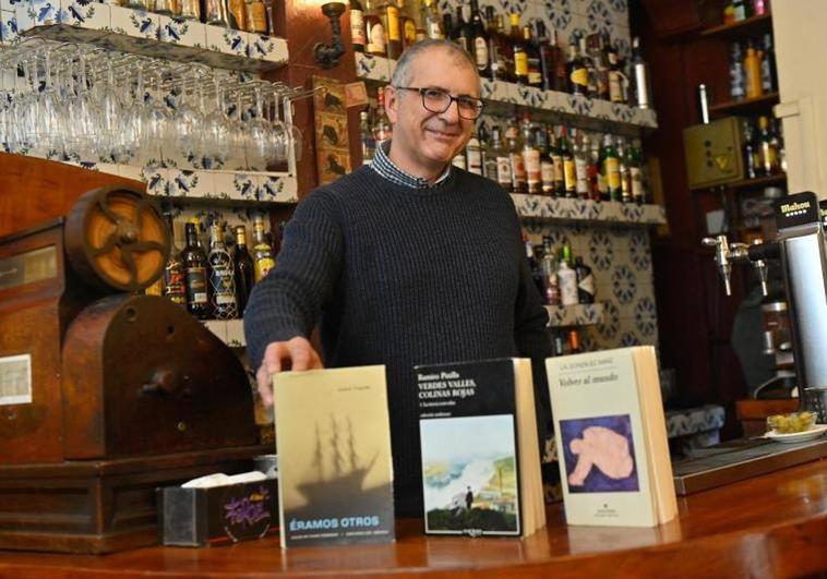 José Luis Castrillón, en la barra de El largo adiós, junto a los libros recomendados.