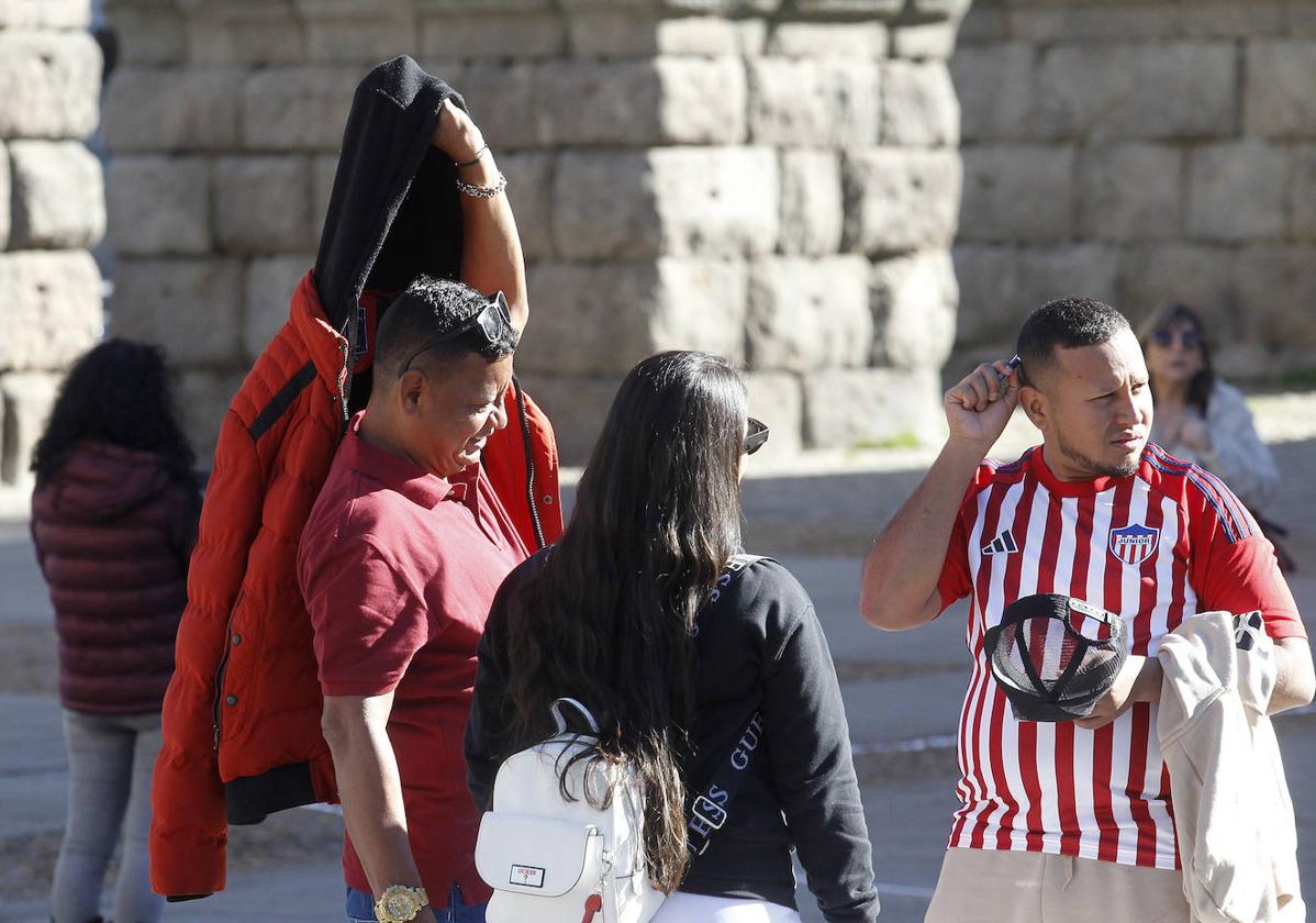 Dos hombres se quitan la chaqueta este miércoles en el centro de Segovia.