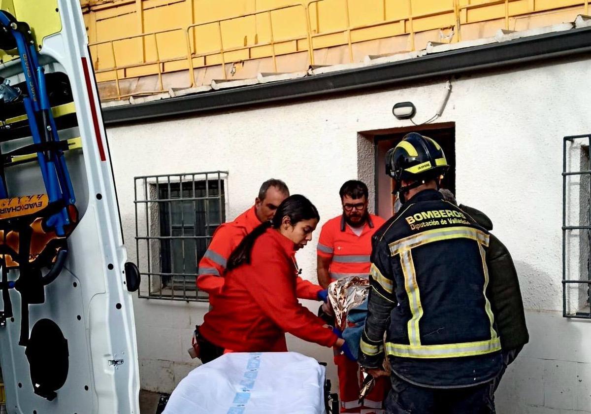 Bomberos y equipo médico de Peñafiel, en la puerta del lugar donde ha sido atendido y estabilizado el accidentado.