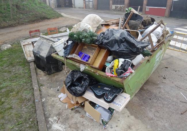 Contenedor repleto de muebles y enseres destrozados por la riada en la calle del Río de Viana.