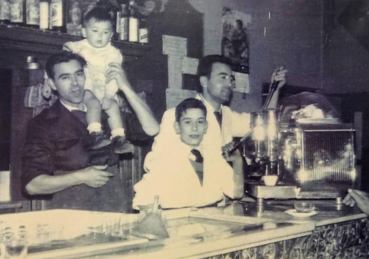 Imagen principal - Arriba, los hermanos Herrero del Moral, Julio y Luis, con un trabajador de la cantina y Julio, hijo de Julio y nieto de Hermógenes. Abajo, Julio Herrero, ante la puerta del negocio Bodegas Hermógenes, en el 190 del Paseo de Zorrilla. A la derecha, Hermógenes Herrero junto a varios clientes a la puerta de la Puerta del Sol.