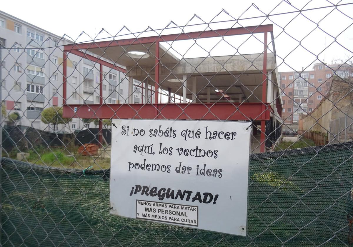 Cartel colocado por los vecinos ante el chasis de la futura sede administrativa de la Seguridad Social en la calle Cardenal Torquemada.