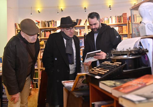 Roger Fariñas muestra un libro a dos lectores en Páramo.