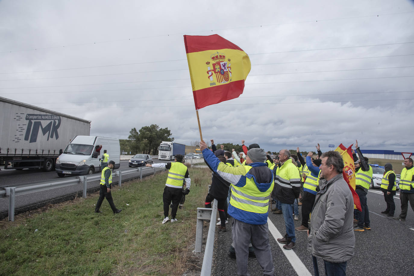 Manifestantes saludan a los conductores de la AP-6 instantes después de la reapertura de la autopista a la altura de Villacastín.