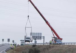 Operarios retirar con una grúa la furgoneta que se había salido de la calzada en la SG-20.