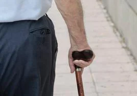Un anciano pasea con su bastón.