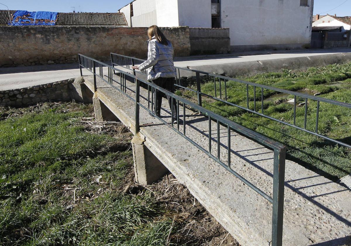 La alcaldesa de Cantimpalos, Inés Escudero, camina por uno de los puentes peatonales que fueron cubiertos por agua.