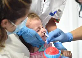 Un niño recibe la vacuna antigripal.