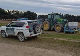 Un vehículo de la Guardia Civil junto al tractor con el que se aplicaba el producto tóxico.