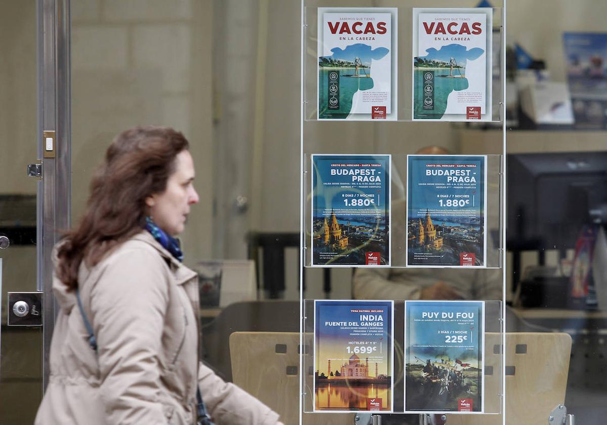 Una mujer pasea junto a una agencia de viajes en la ciudad de Segovia.