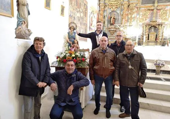 Varios socios de la Asociación La Fe de Socorros Mutuos de la Clase Obrera de Megeces ante la imagen del Santo Ángel de la Guarda.