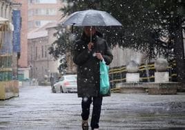 Un hombre camina en Valladolid bajo la nieve.