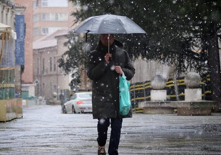 Un hombre camina en Valladolid bajo la nieve.