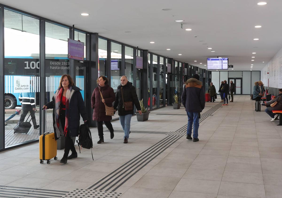 Varios viajeros llegan a Palencia y atraviesan la zona entre las dársenas y el vestíbulo, hoy enb la Estación de Autobuses.