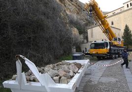 Un camión grúa, junto a un contenedor de obra con los cascotes retirados.