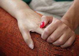 Una mujer coge la mano de un enfermo de ELA: