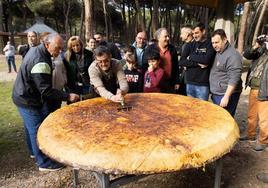 Jesús Martín parte la tortila de patata gigante en raciones.