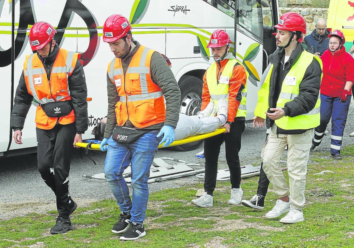 Los alumnos trasladan en camilla a un supuesto herido durante el simulacro.