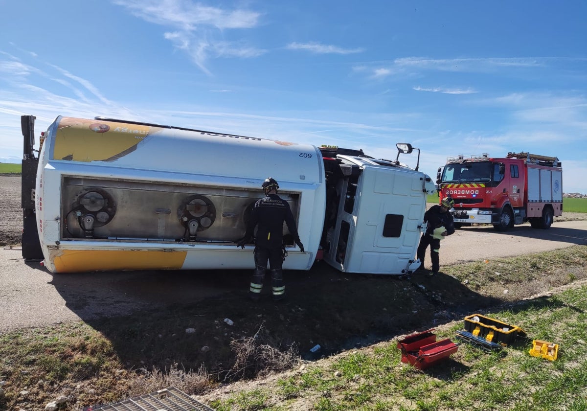 Los Bomberos del parque de Peñafiel durante su intervención en el accidente, sellando el escape de gasóleo.