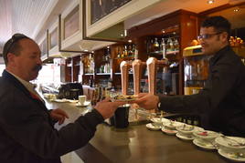 Un hombre recibe las pastas de chocolate en un bar en Aguilar de Campoo.