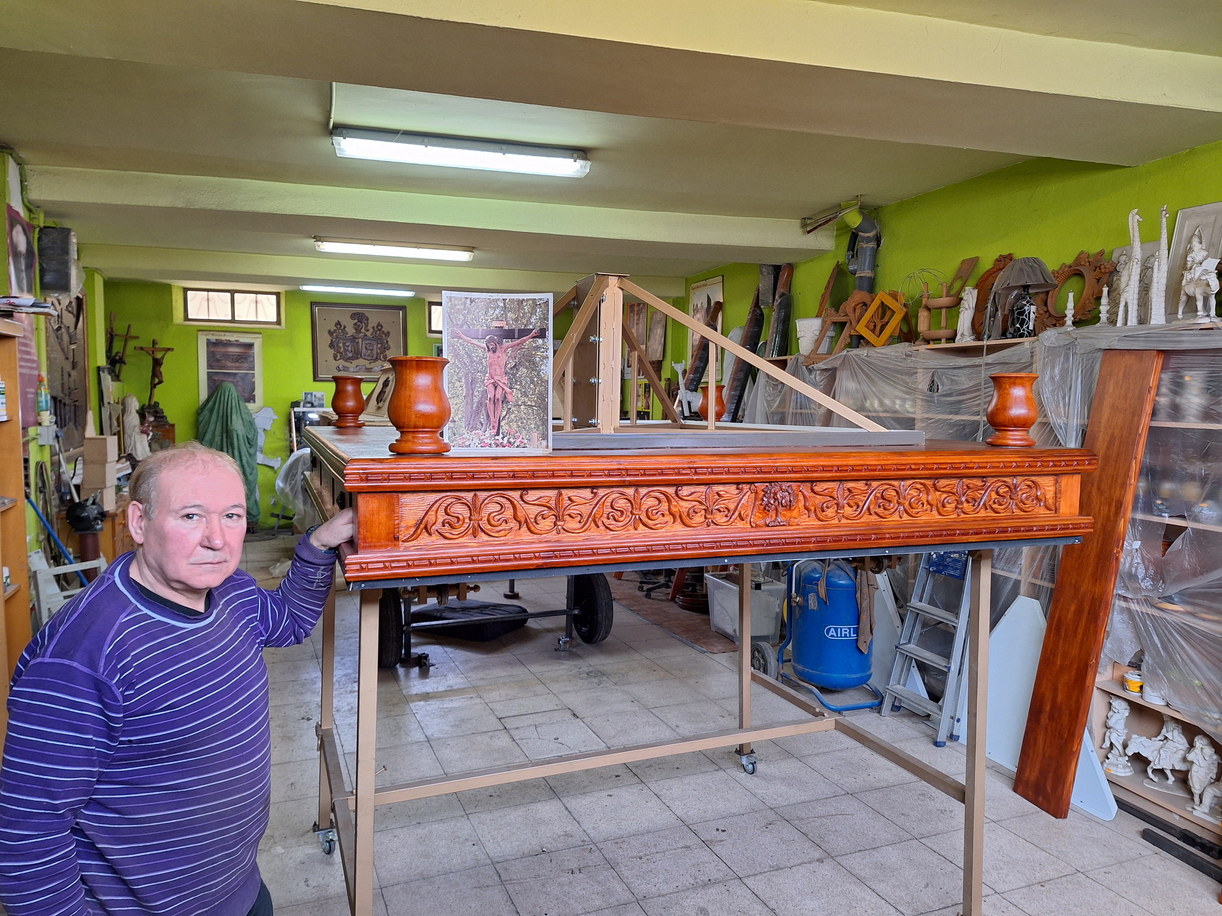 El imaginero riosecano Ángel Martín, junto a las andas del Cristo de l aLuz que ha decorado en su taller.