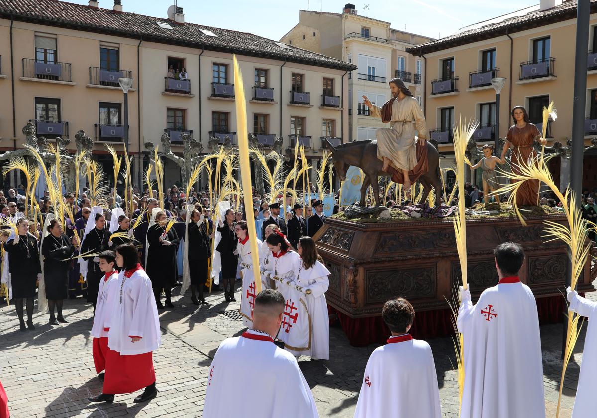 Los cofrades agitan las palmas al paso de 'la borriquilla'.