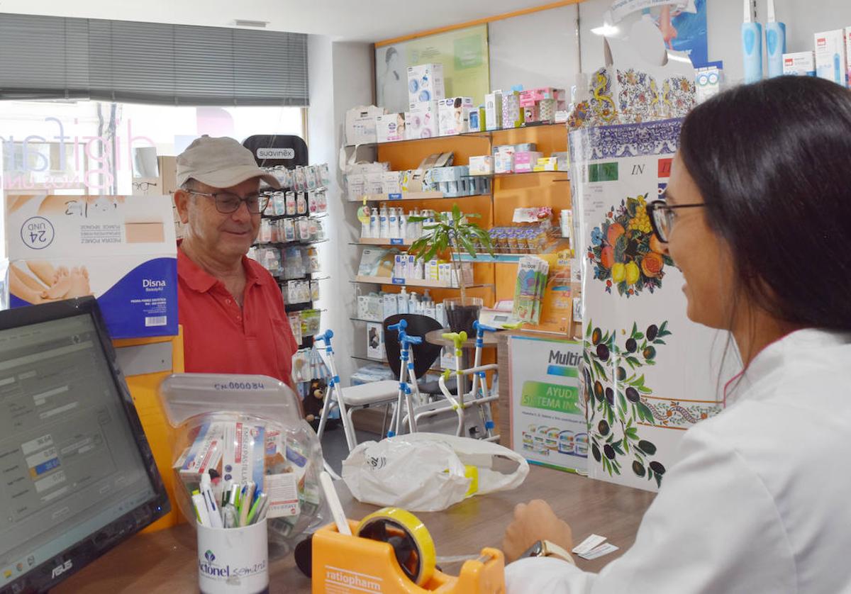 Una farmacéutica atiende a un cliente en Aguilar de Campoo.