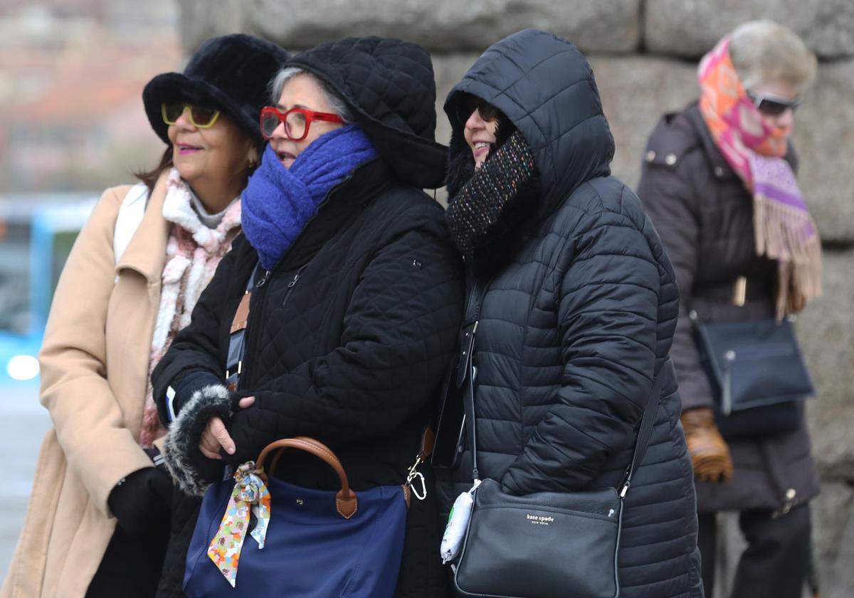 Varias mujeres pasean abrigadas este martes por el centro de la ciudad de Segovia.