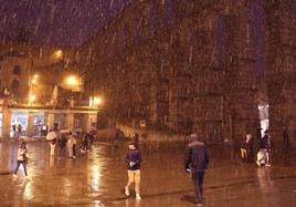 Multitud de personas caminan bajo la lluvia junto al Acueducto, este martes.