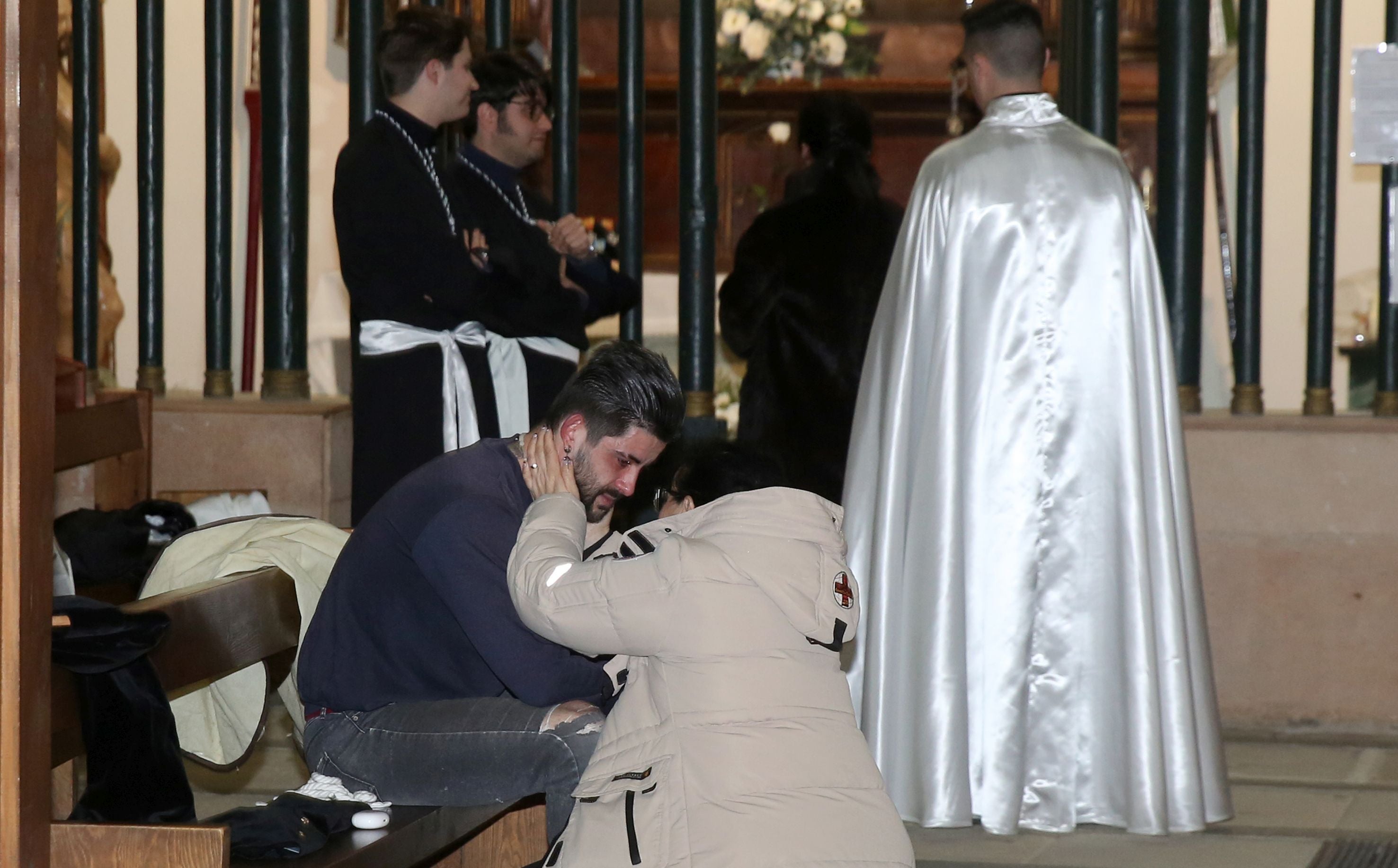 Una mujer consuela a un hombre disgustado por la suspensión de la Procesión de los Cinco Misterios de Santa Eulalia.