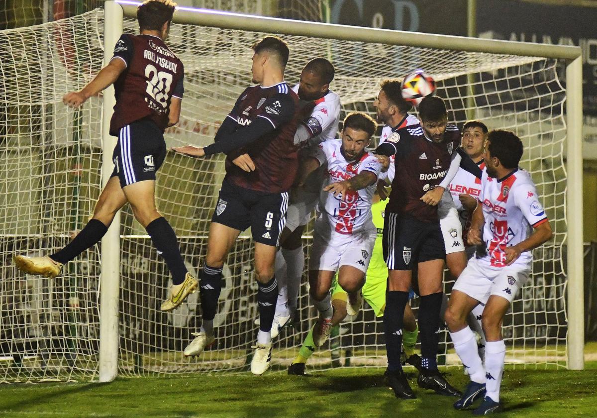 Jugadores gimnásticos tratan de rematar un saque de esquina.