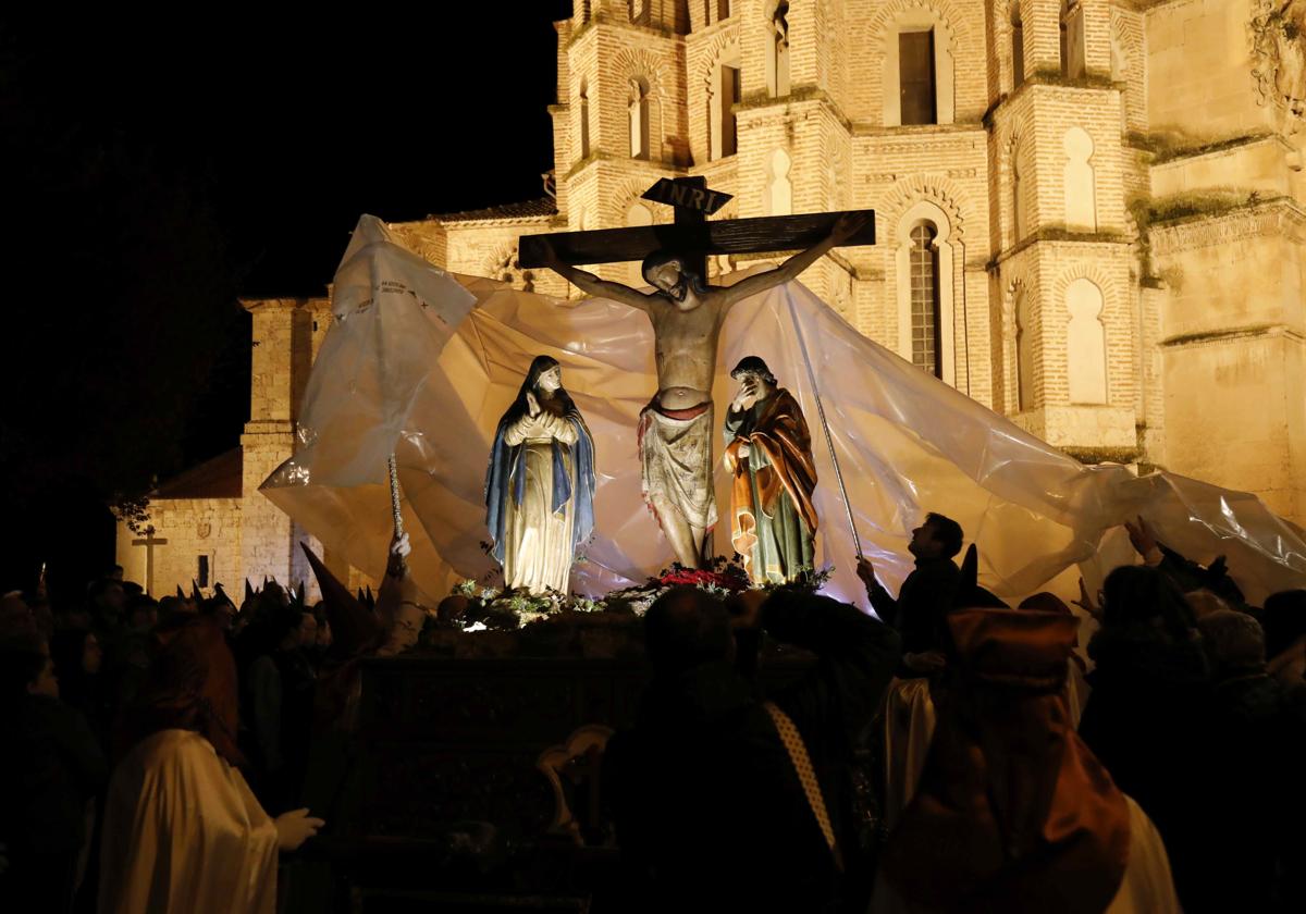 Talla del Cristo de la Buena Muerte siendo cubierta por un gran plástico a su paso por la iglesia de San Pablo.