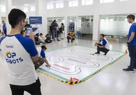 La carrera de robots velocistas atrae la atención de varios alumnos en el edificio de Induva.