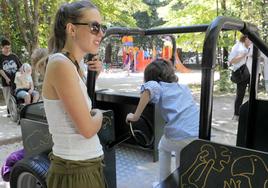 Una niña juega con sus asistentes personales en el Campo Grande de Valladolid.