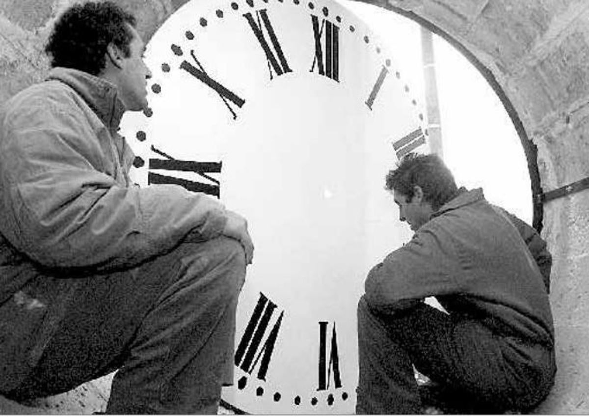 Imagen secundaria 1 - Colocación de la nueva esfera y, abajo a la derecha, antigua esfera de madera del reloj de la catedral.