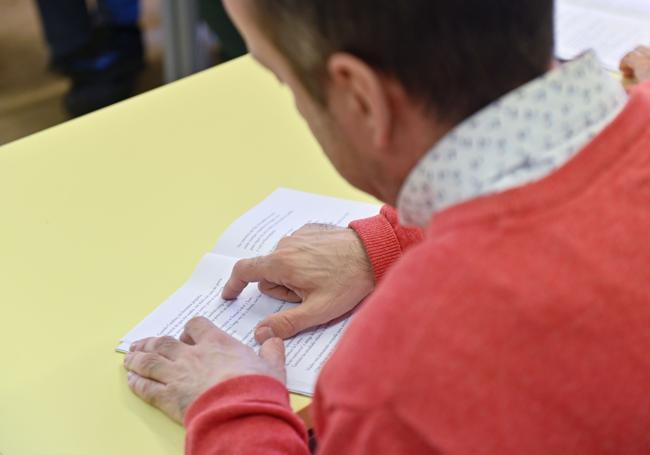 Un lector sigue la lectura en grupo.