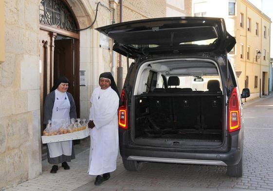 Dos religiosas se disponen a cargar la furgoneta.