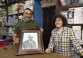 Carlos Campos y María Rosa Sigüenza, con una foto del fundador de la tienda de Tordesillas, Alejando Sigüenza.