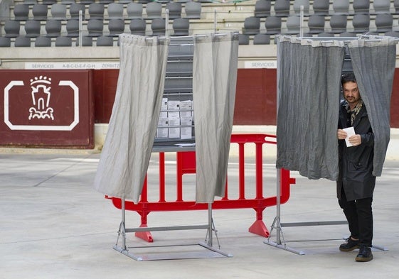 Un hombre sale de la cabina de votación en un colegio electoral situado en una plaza de toros en Vitoria.