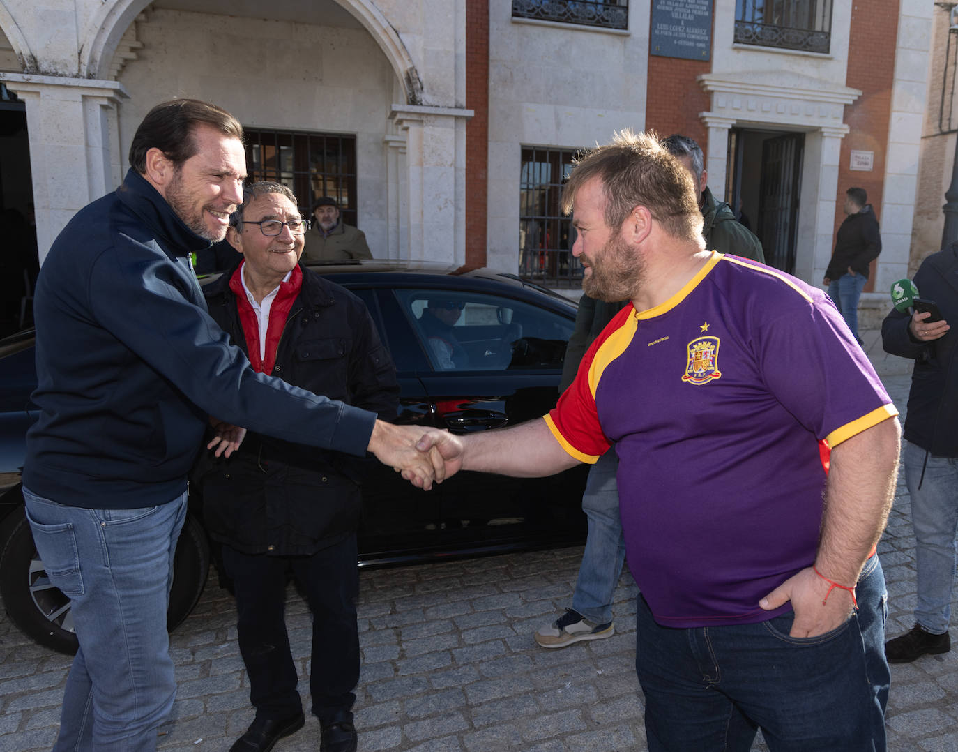 Óscar Puente, ministro de Transportes, saluda a uno de los asistentes a Villalar en presencia del alcalde de la localidad.