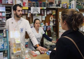 Una joven pide unos medicamentos en una farmacia de la capital segoviana.