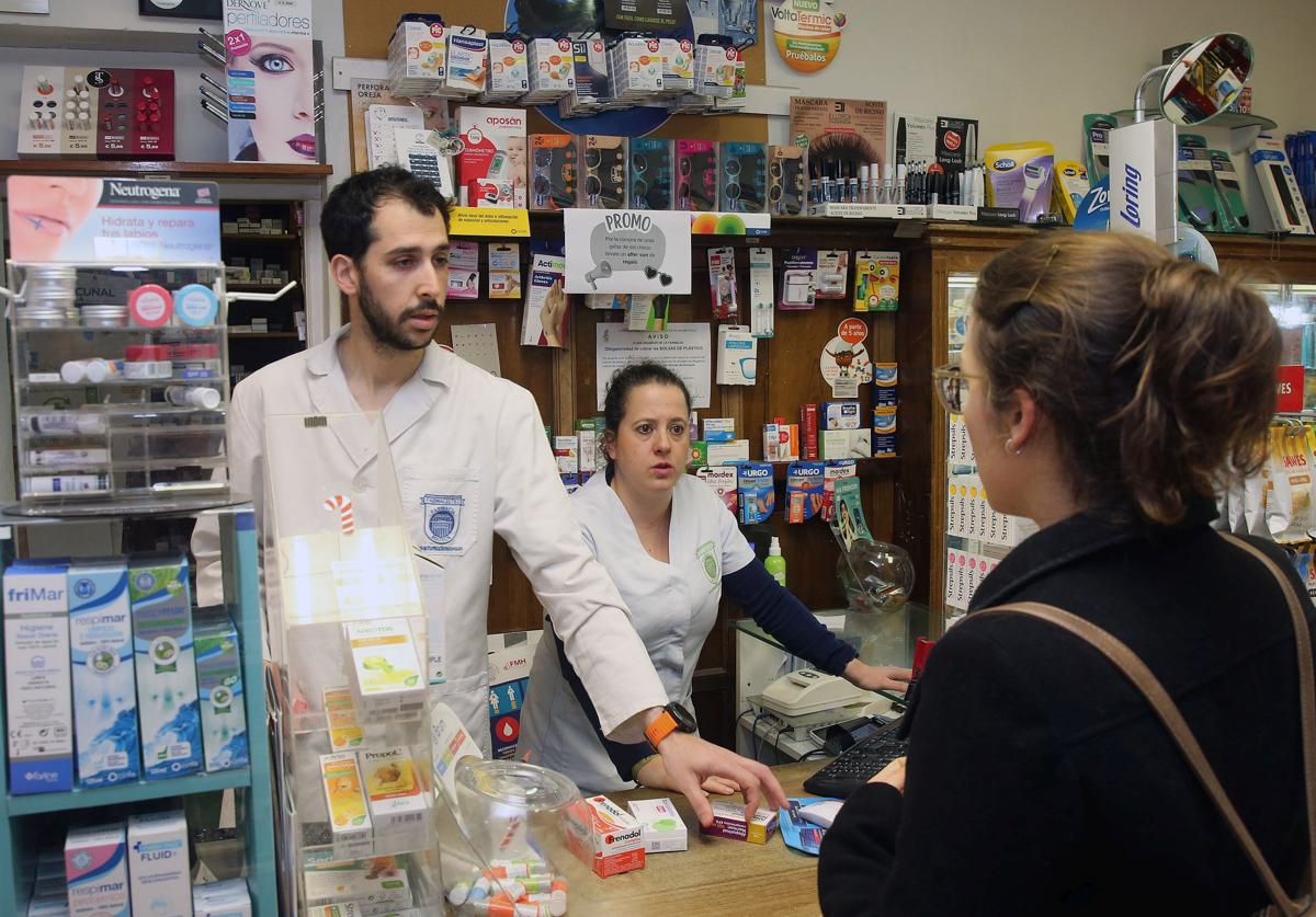 Una joven pide unos medicamentos en una farmacia de la capital segoviana.