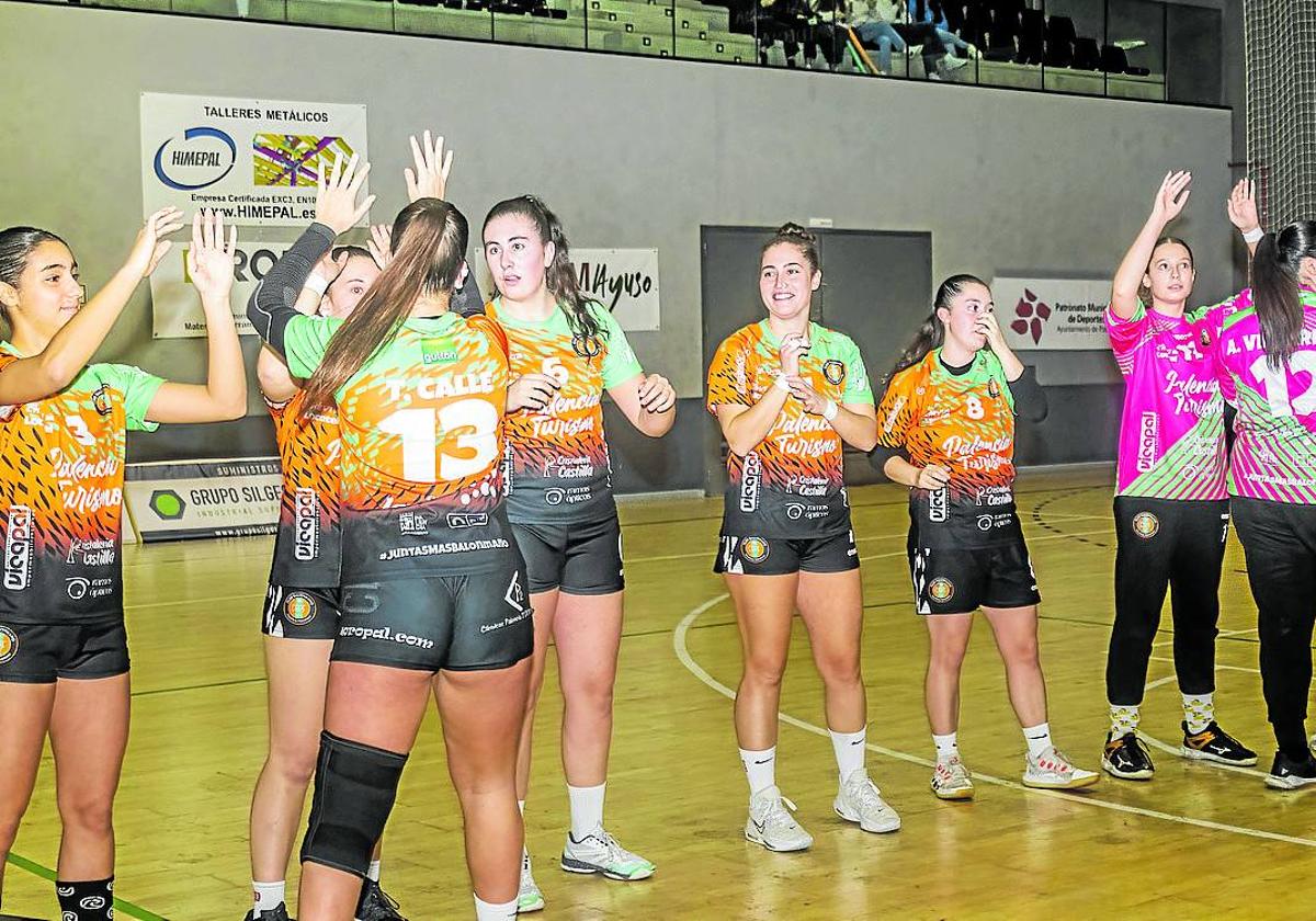 Las jugadores del Palencia Turismo se saludan en su entrada en la cancha.