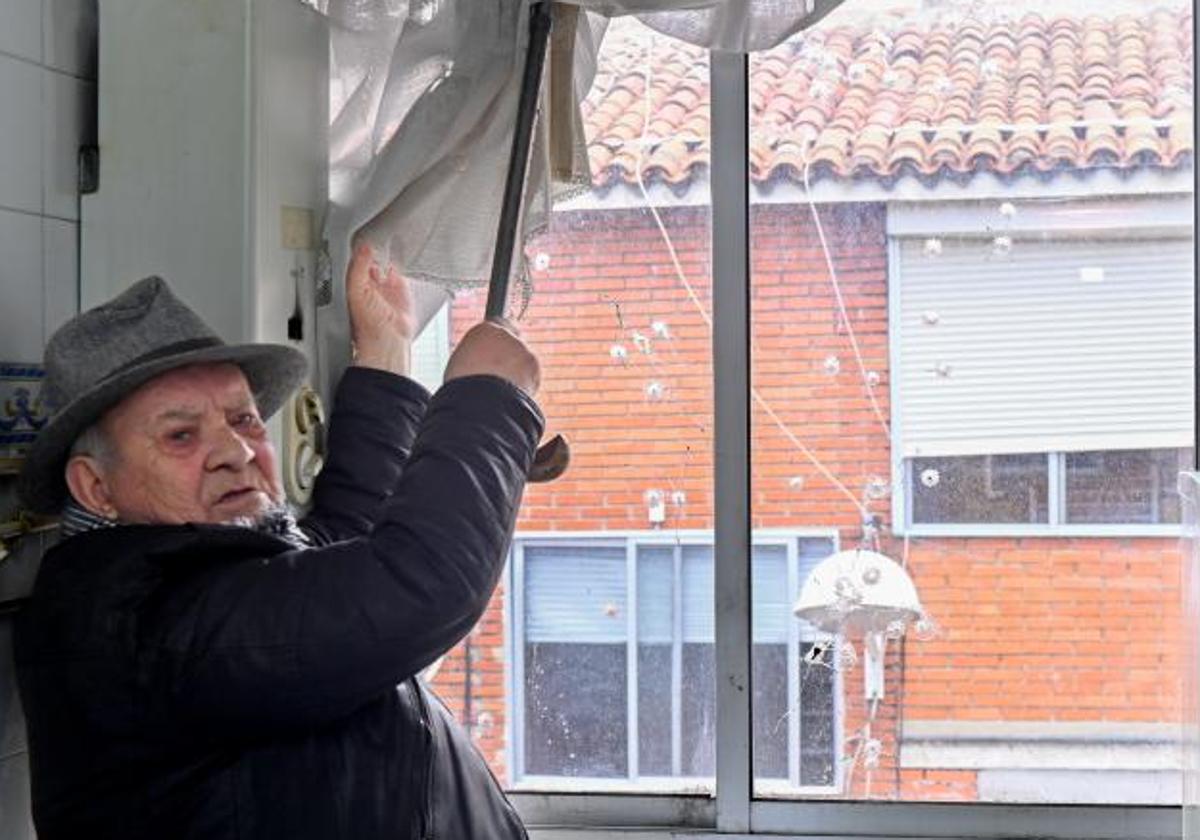 Juan Vázquez Díaz, de 82 años, muestra unos disparos en la ventana de su vivienda.