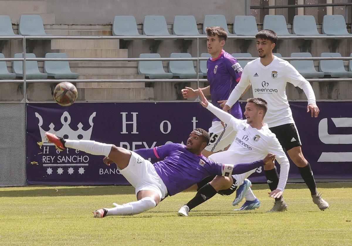 Edipo intenta hacerse con el balón ante la oposición de la defensa del Burgos B.