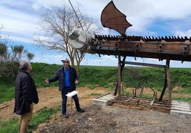 El alcalde muestra al delegado de la Junta una escultura hecha con aperos de labranza.