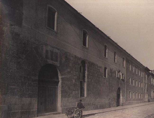 Un aguador pasa frente al Colegio de los Escoceses en 1865.